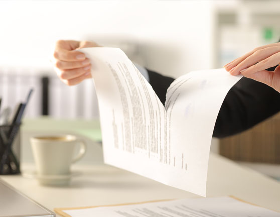 Persona rompiendo un documento en dos