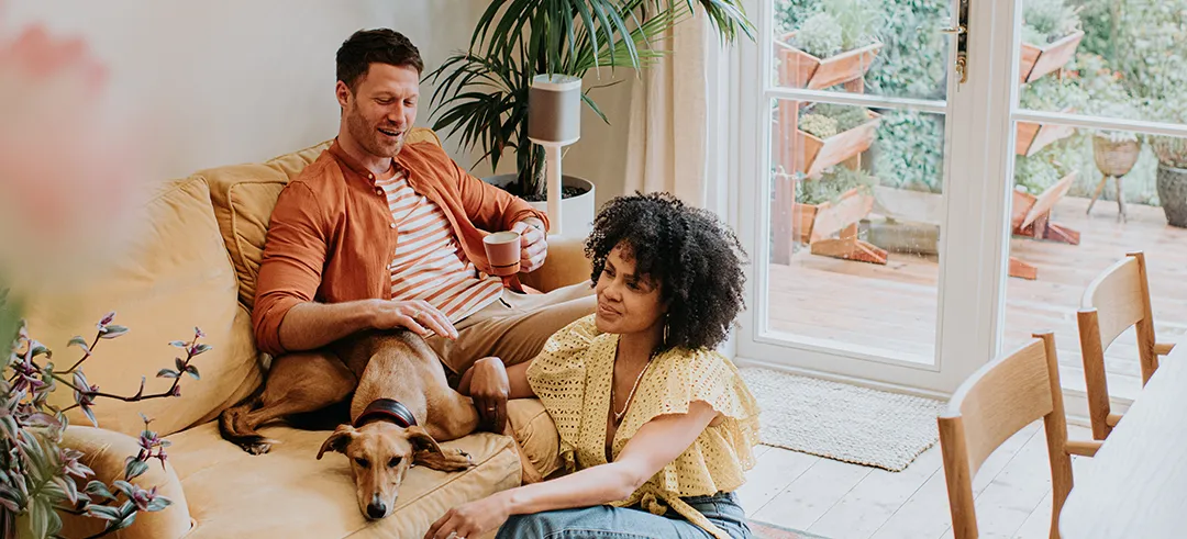 Dos personas y un perro hablando en el salón