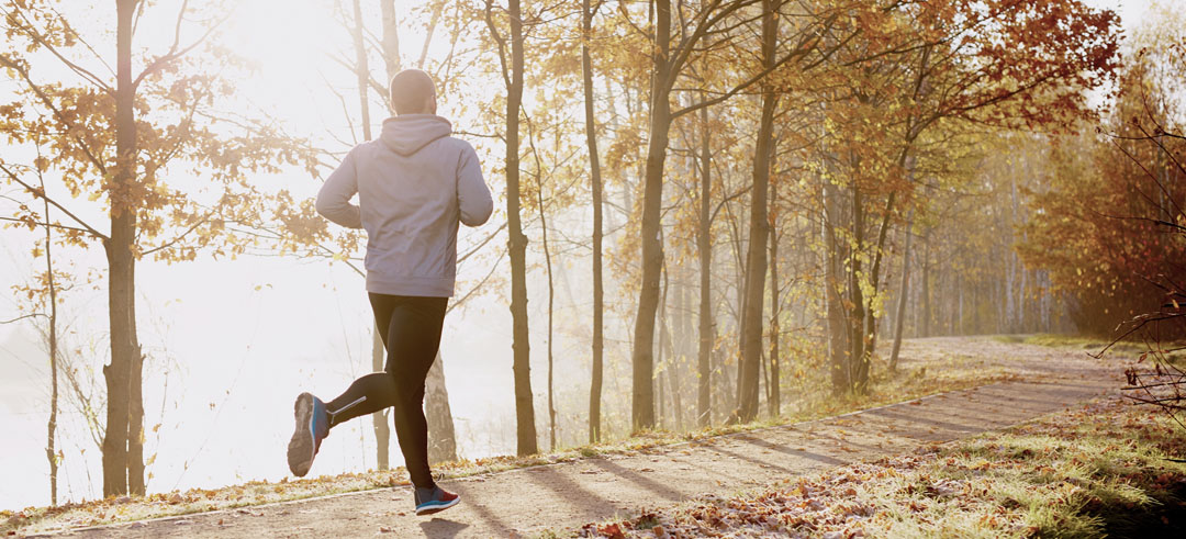 Hombre corriendo por un parque en otoño
